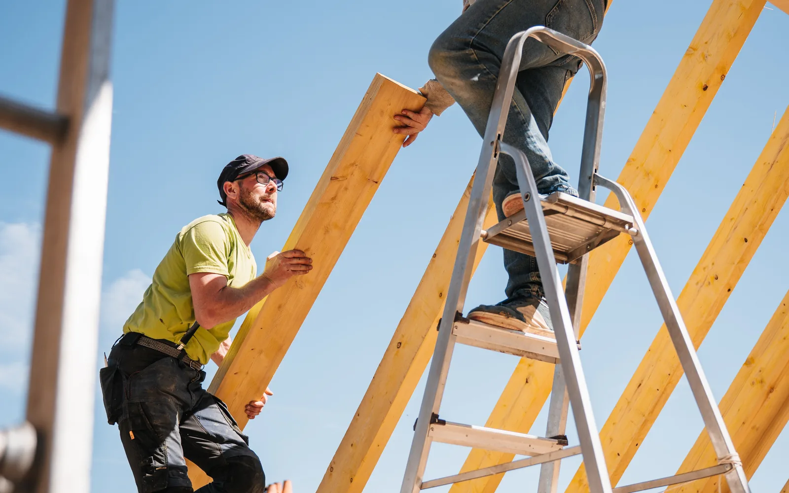 Construction workers assembling wood rafters for a new roof structure.